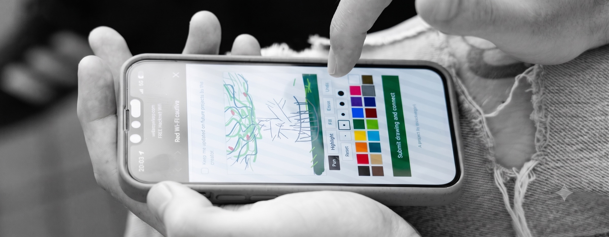 A contributor draws on FREE Hackney Wifi; the scene is black and white while the drawing on screen stays in colour.